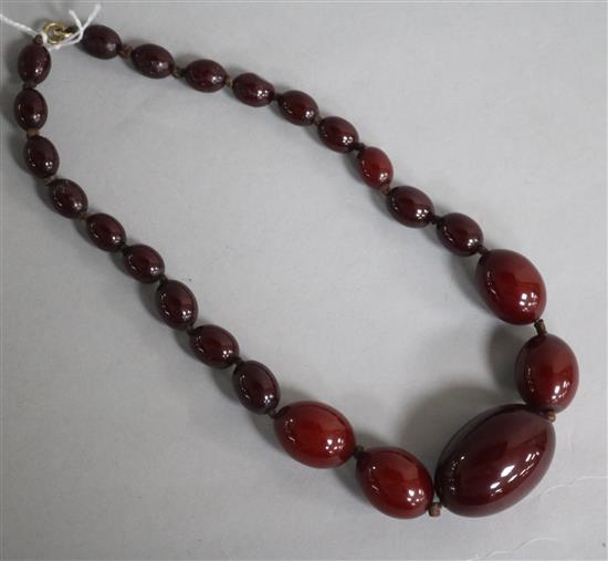 A single strand graduated simulated cherry amber bead necklace, 38cm.
